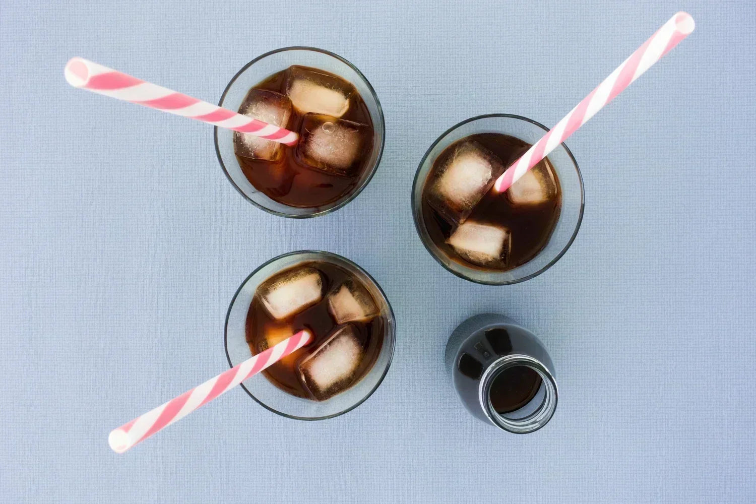 Three glasses of cold brew coffee concentrate with ice and straws