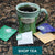 Assorted tea-bags, some in wrapper and some out of wrapper, sitting on granite counter with green mug with Mystica Tea logo in the background. Text reads Shop Tea